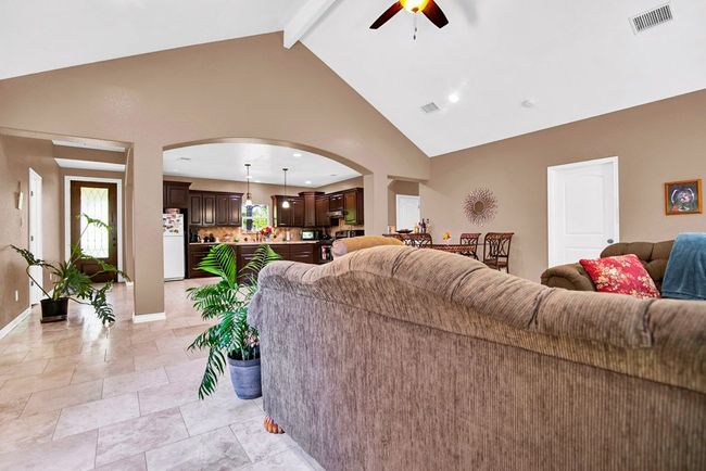 Living area featuring high vaulted ceiling, ceiling fan, arched walkways | Image 13