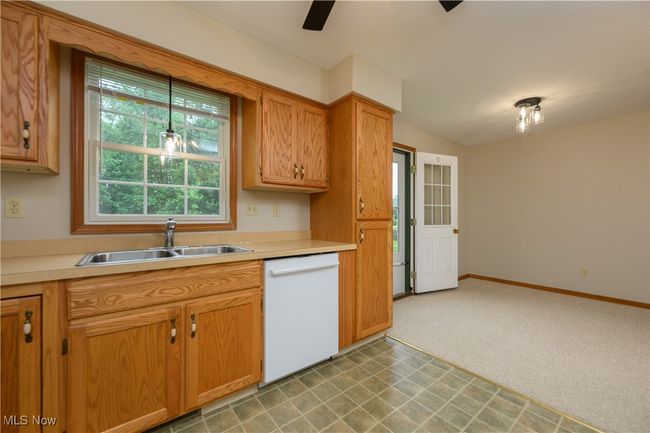 Kitchen with dishwasher, light countertops, a ceiling fan, and light floors | Image 12