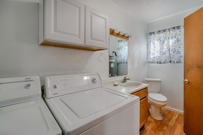 Laundry room featuring separate washer and dryer, light hardwood / wood-style floors, and sink | Image 34