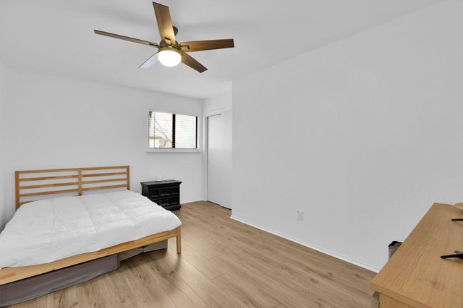 Bedroom with light wood finished floors, ceiling fan, and a closet | Image 23