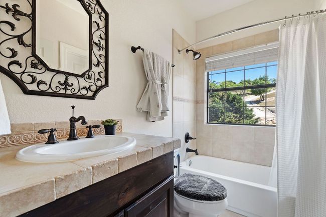 Bathroom with toilet, vanity, and shower / tub combo with curtain | Image 38