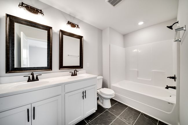 Modern finishes continued into your primary bath with tile, and double raised vanities. | Image 29