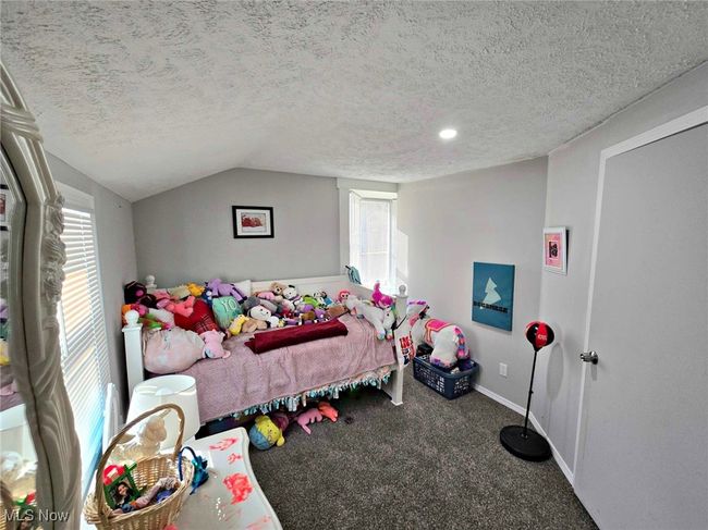 Carpeted bedroom with baseboards, a textured ceiling, and vaulted ceiling | Image 43