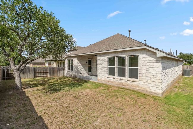 Back of house featuring a shingled roof, a fenced backyard, and stone siding | Image 35