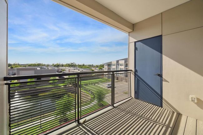 Covered balcony with a storage room. Enjoy the view of the community pond. | Image 17