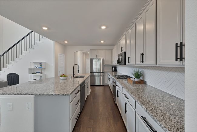 Kitchen featuring a sink, backsplash, appliances with stainless steel finishes, and dark wood-type flooring | Image 10