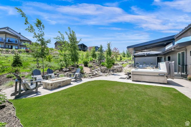 View of grassy yard with an outdoor fire pit and a patio | Image 65