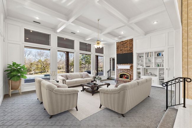Tranquility surrounds you in this Great Room with the wall to wall windows and a cozy fireplace. Virtually Staged. | Image 17