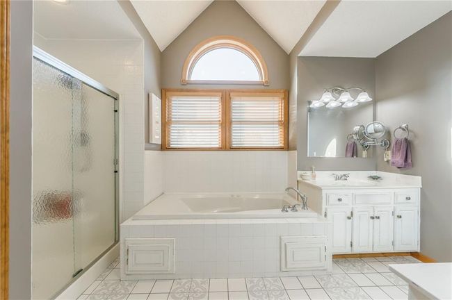 Bathroom featuring lofted ceiling, a bath, a shower stall, tile patterned floors, and vanity | Image 36