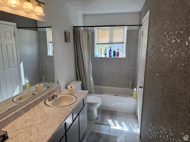 Full bathroom featuring shower / bath combo, toilet, tile patterned floors, and plenty of natural light | Image 10