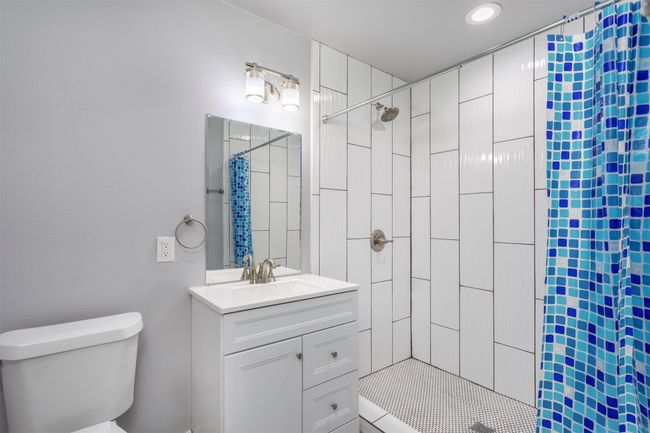 Bathroom with vanity, curtained shower, and toilet | Image 19