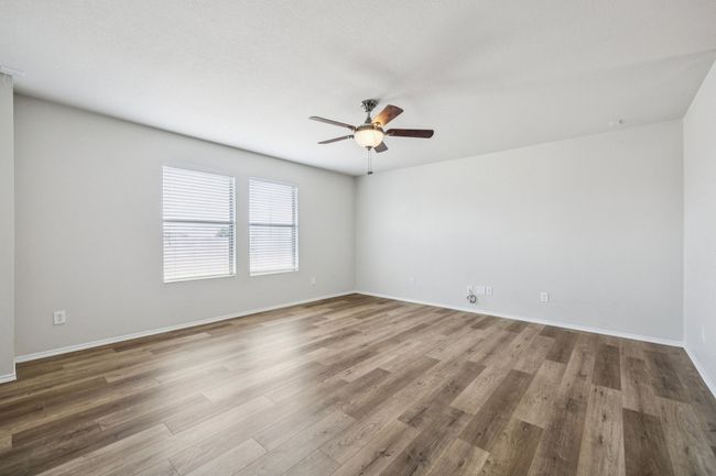 Second living area or gameroom featuring a ceiling fan and wood finished floors | Image 20