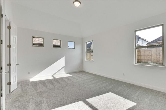 Empty room with carpet flooring and lofted ceiling | Image 8