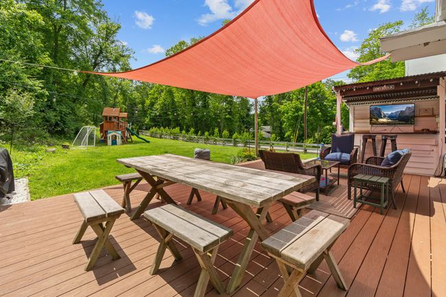 Wooden terrace with outdoor dining space and a playground | Image 11