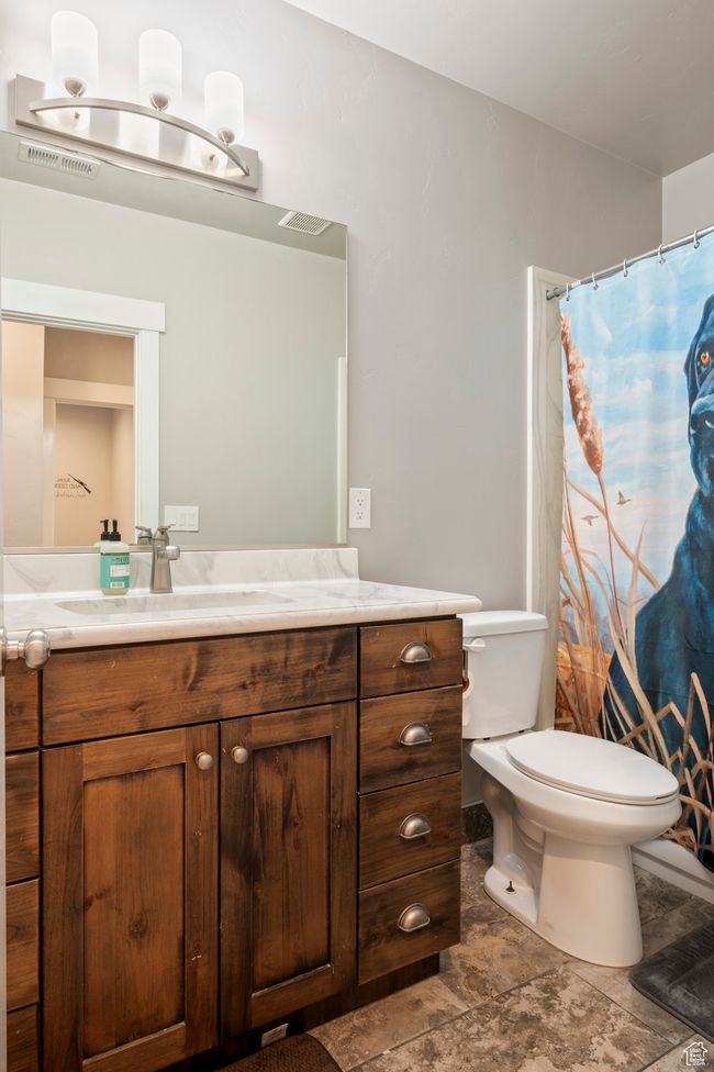 Bathroom featuring visible vents, toilet, a shower with shower curtain, and vanity | Image 27