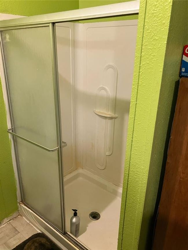 Bathroom with a shower with door and tile patterned floors | Image 20