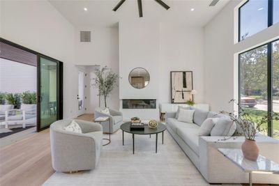 Living room featuring ceiling fan, light hardwood / wood-style flooring, and a high ceiling | Image 3