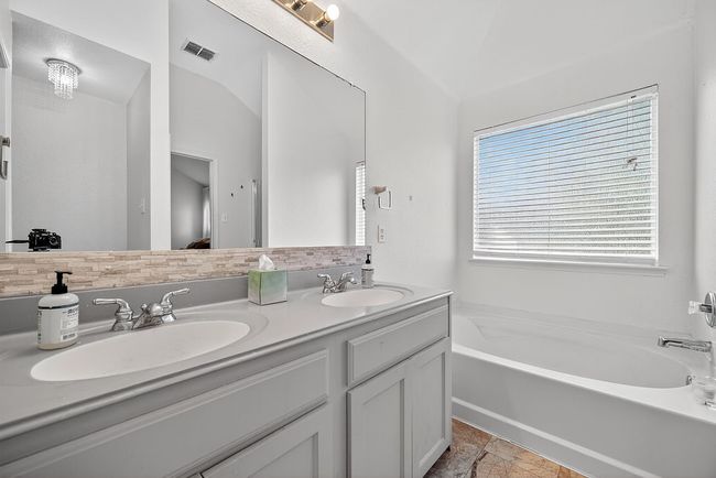 Full bathroom with double vanity, a garden tub, and lofted ceiling | Image 26