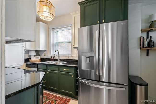 Kitchen with dark stone counters, green cabinetry, and stainless steel appliances | Image 15