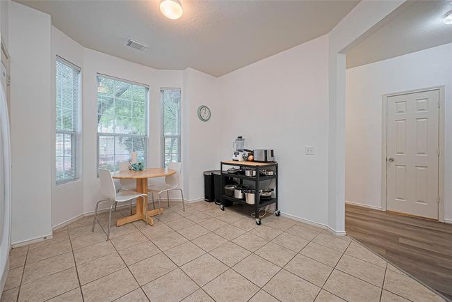 Spacious kitchen with plenty of room for a table and a mini coffee bar against the wall. | Image 12