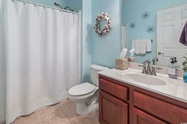 Full bath with tile patterned floors, vanity, and a shower with shower curtain | Image 16