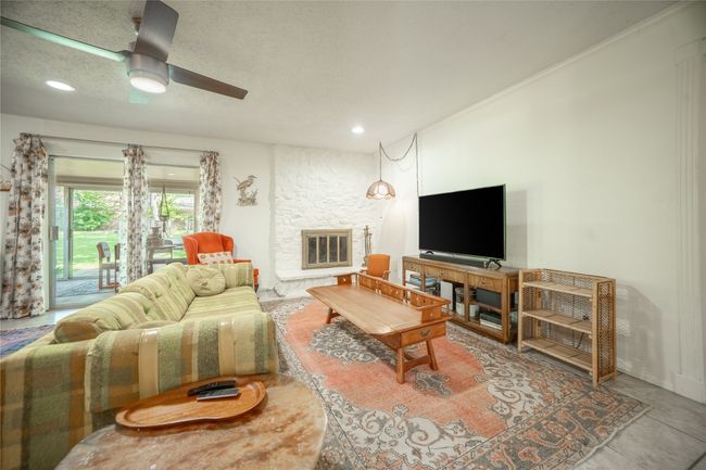 Living room with ornamental molding, recessed lighting, a stone fireplace, and ceiling fan | Image 4