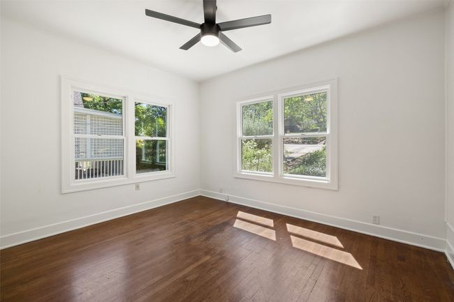 Spare room with dark wood-style flooring, baseboards, and ceiling fan | Image 18
