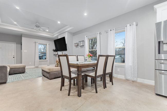 Dining room featuring a raised ceiling and ceiling fan | Image 9