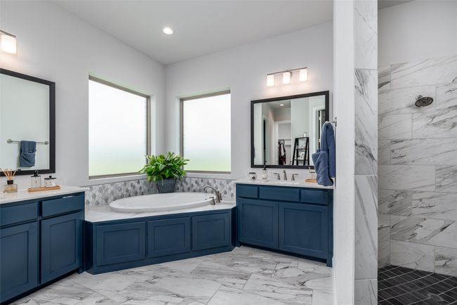 Bathroom featuring marble look tiles, two vanities, a garden tub, a tile shower, and recessed lighting | Image 16
