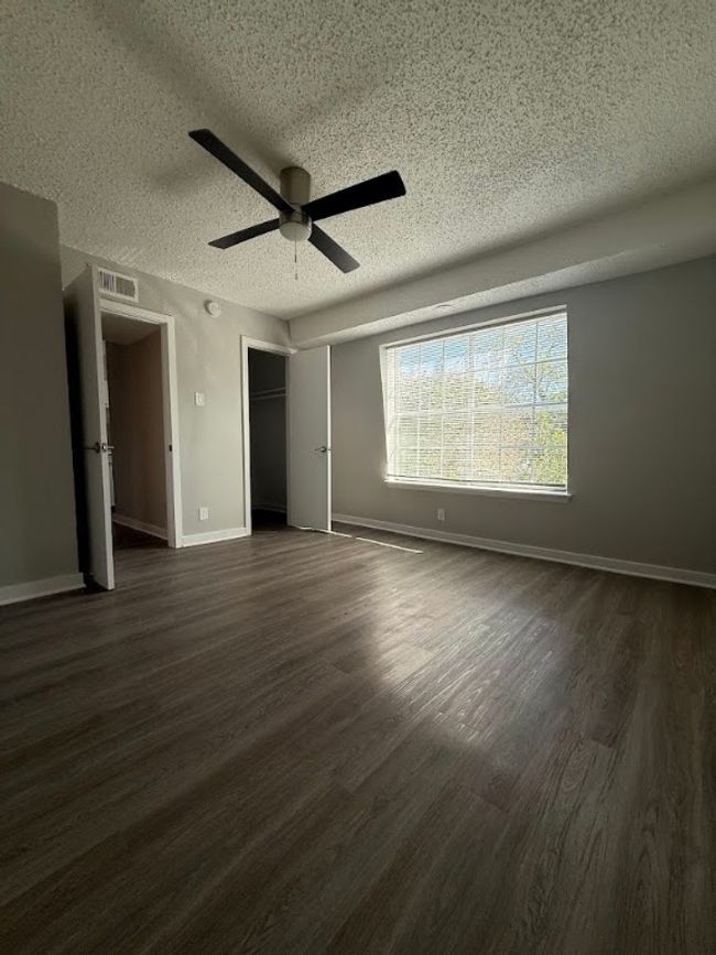 Unfurnished bedroom featuring a textured ceiling, dark wood-type flooring, baseboards, a ceiling fan, and a closet | Image 15