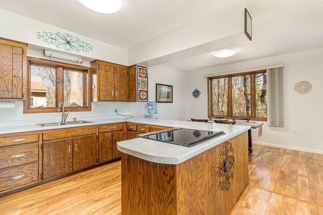The kitchen is filled with natural light from all the large windows. It's open to the informal dining room & the great room, making it perfect for entertaining. There is a large amount of cabinet storage & counter space for all your cooking needs. | Image 15