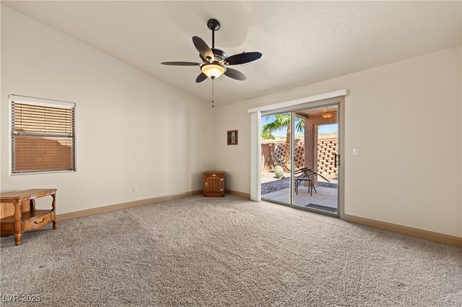 Carpeted empty room featuring lofted ceiling and a ceiling fan | Image 30
