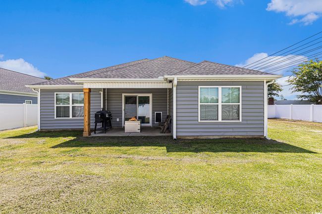 Rear view of house with a patio, a fenced backyard, and a shingled roof | Image 30