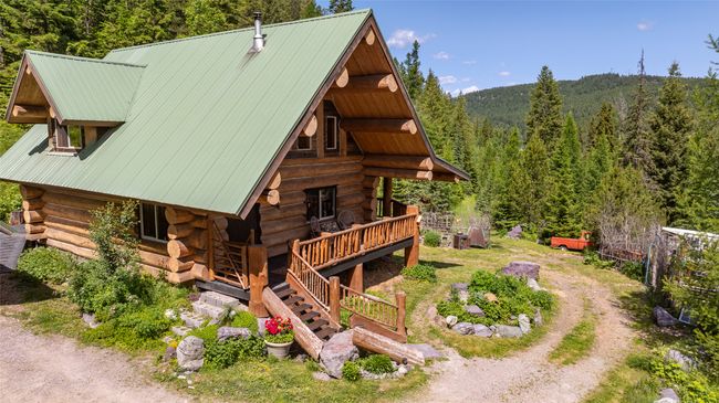 View of home's exterior featuring log siding, a view of trees, and metal roof | Image 72