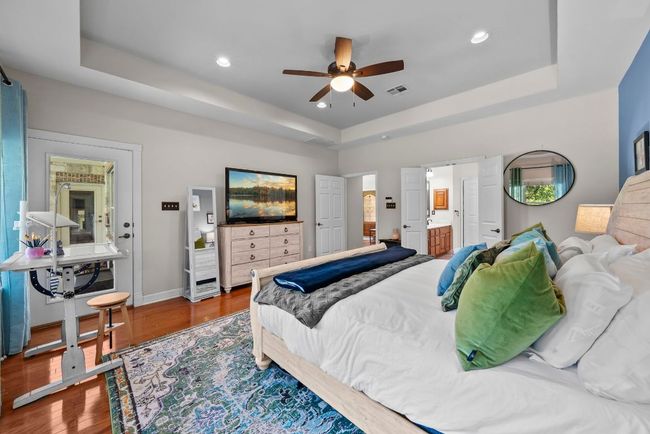 The serene owner's retreat is a peaceful sanctuary with a tray ceiling and a spacious en-suite bath | Image 15