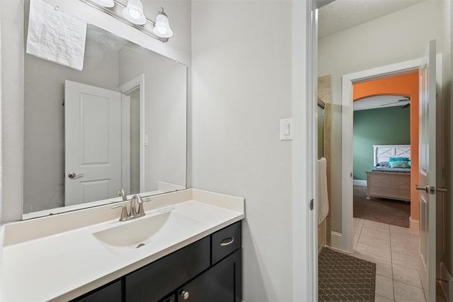 Jack-and-Jill style bathroom featuring a spacious vanity with updated fixtures, a large mirror, and a separate tub/shower area for added privacy. Conveniently connects two upstairs bedrooms, making it ideal for siblings or guests. | Image 21
