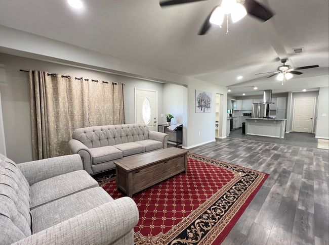 Living room with ceiling fan, dark wood-type flooring, recessed lighting, and lofted ceiling | Image 8