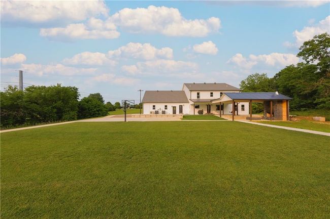 Modern farmhouse style home featuring a front yard, a patio area, and metal roof | Image 69