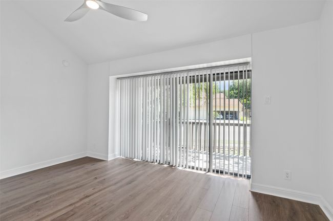 Downstairs en-suite bathroom with sliding doors to large patio area. Features include brand new flooring, custom fan and lots of natural light. | Image 9