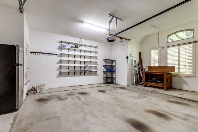 Oversized garage with workbench and extra shelving. | Image 31