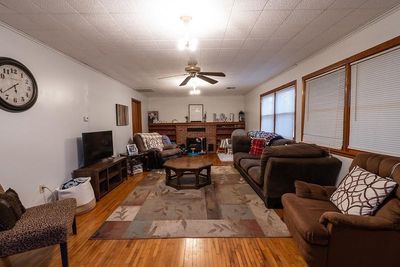 Living room with ceiling fan, light hardwood / wood-style flooring, and a brick fireplace | Image 3