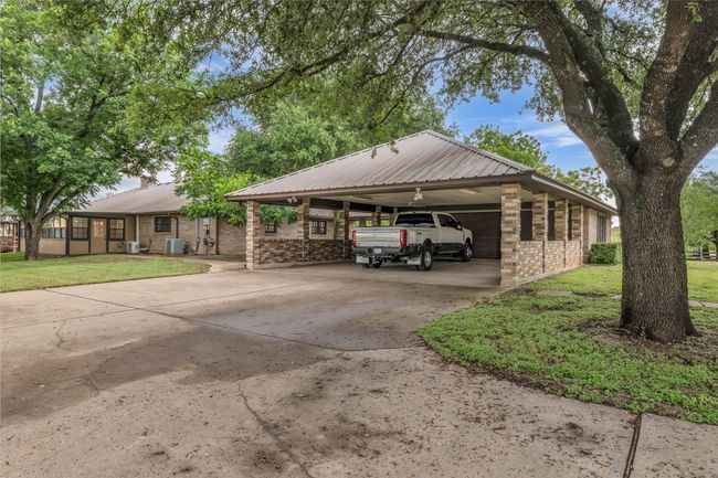 View of front of home featuring brick siding, driveway, a front lawn, and an attached carport | Image 8
