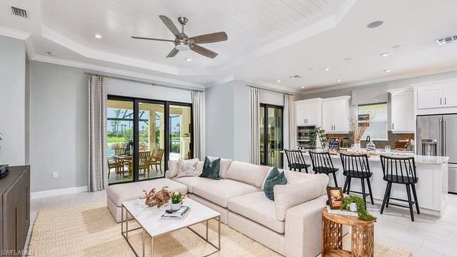 Living room featuring recessed lighting, visible vents, a tray ceiling, and ceiling fan | Image 9