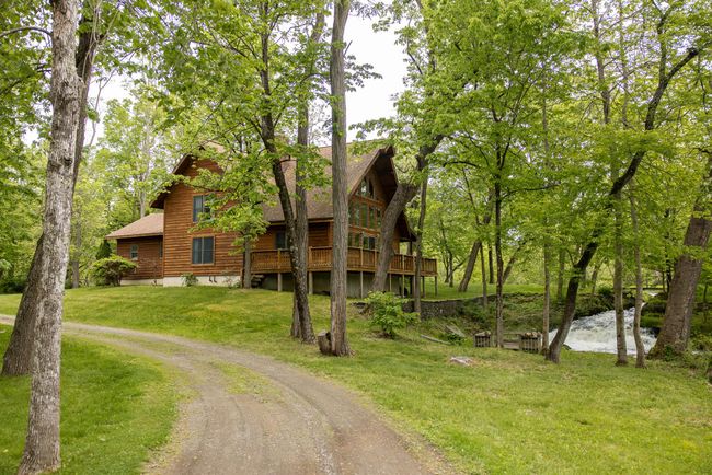 View of front of home with a front yard, a wooden deck, roof with shingles, and driveway | Image 38
