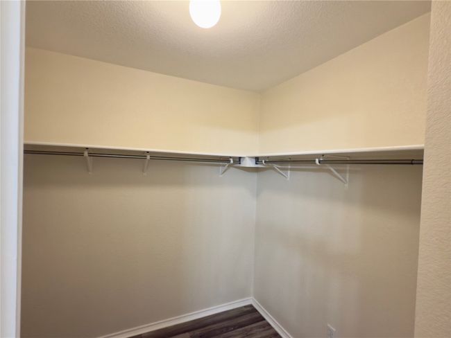 Spacious closet with dark wood finished floors | Image 26