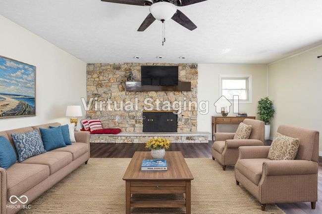 detailed view of a stone fireplace, wood finished floors, and a textured ceiling | Image 10