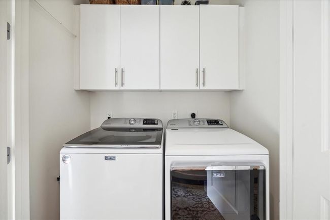 The laundry area is behind folding doors in the hallway. The full size washer and dryer were recently replaced, and they stay. There is great cabinet space, too. | Image 27