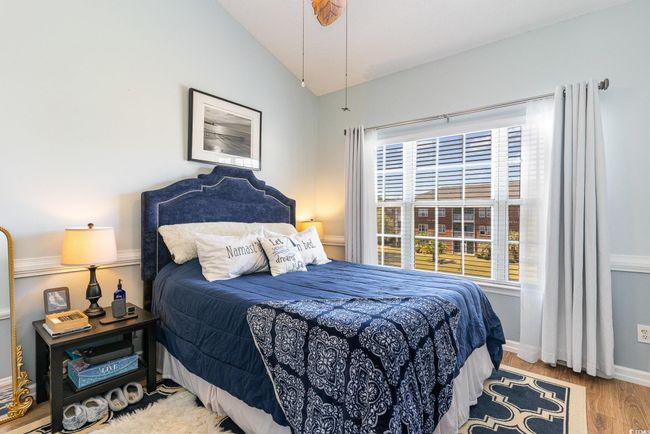 Bedroom with baseboards, lofted ceiling, and wood finished floors | Image 10