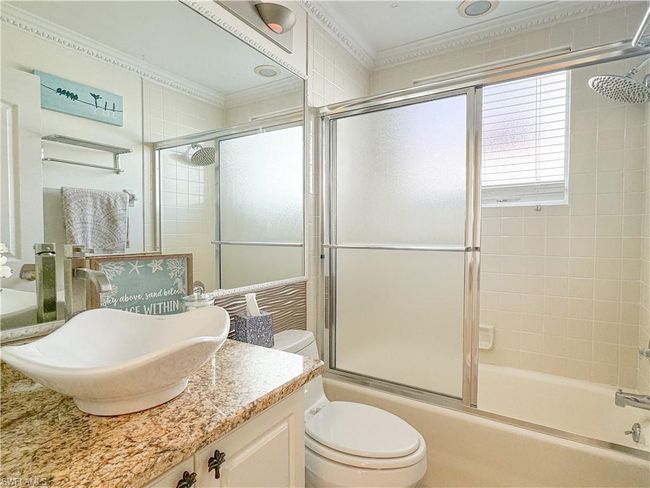 Full bathroom featuring crown molding, toilet, combined bath / shower with glass door, and oversized vanity | Image 21