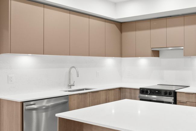Kitchen with dishwasher, electric range oven, modern cabinets, light countertops, and under cabinet range hood | Image 7